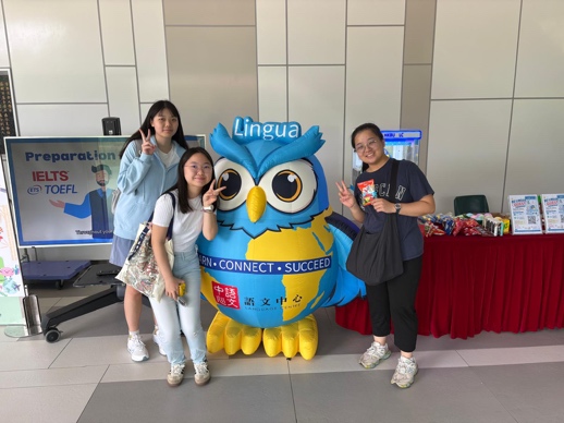 Students beside the Language Centre mascot at the AY2026–27 booth.