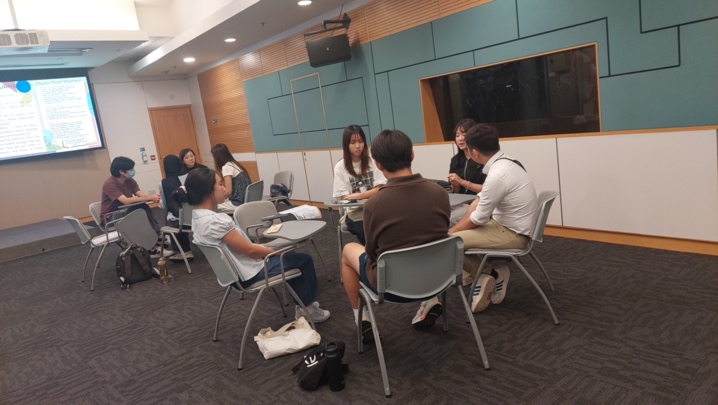 Students and facilitators discussing overseas experiences in a small group.