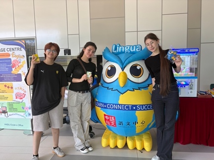 Students posing with the Language Centre mascot at the booth.