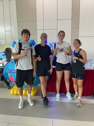 Students holding prizes beside the Language Centre mascot.
